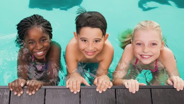 children in pool smiling